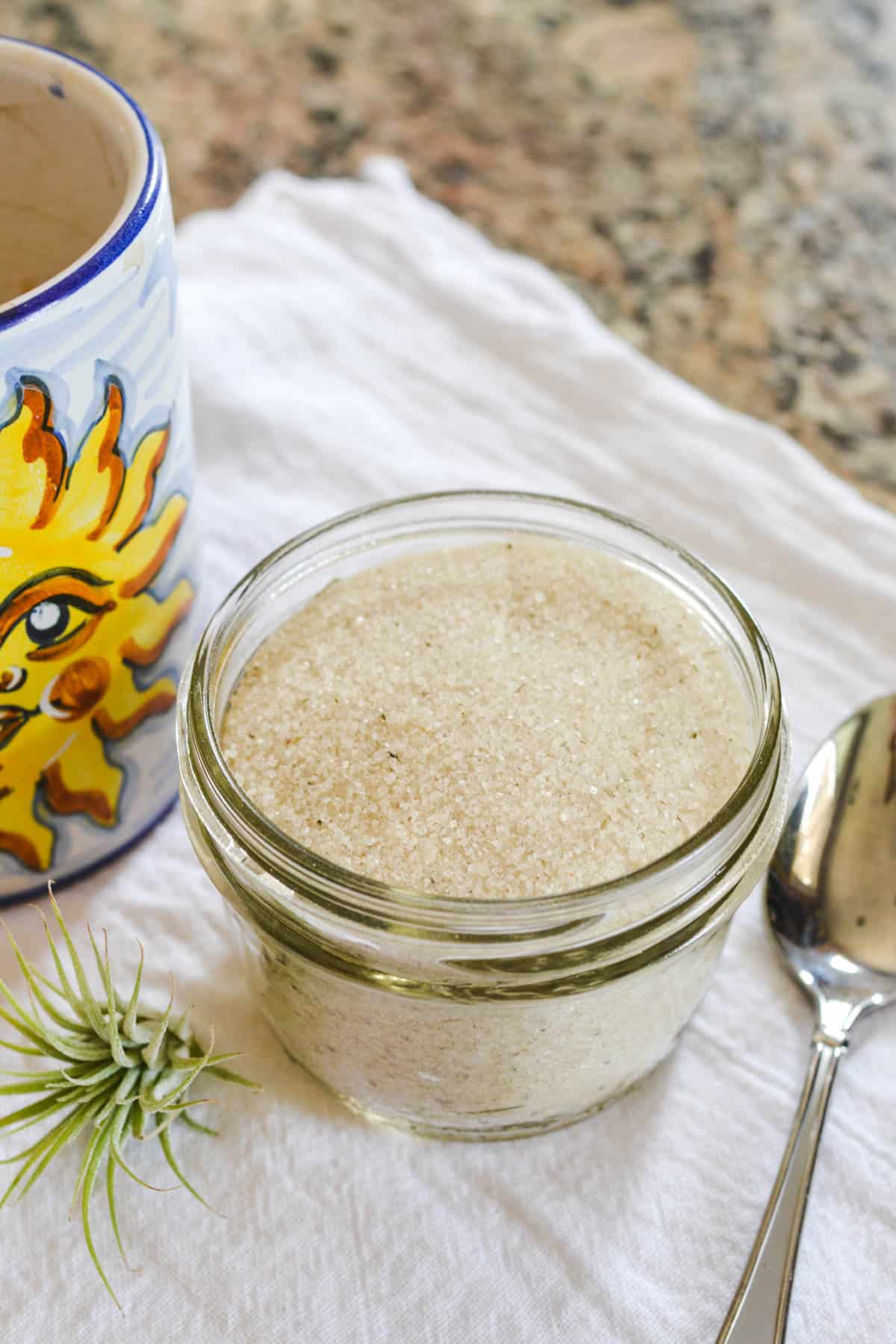 Close up of lavender sugar in a jar on a counter.