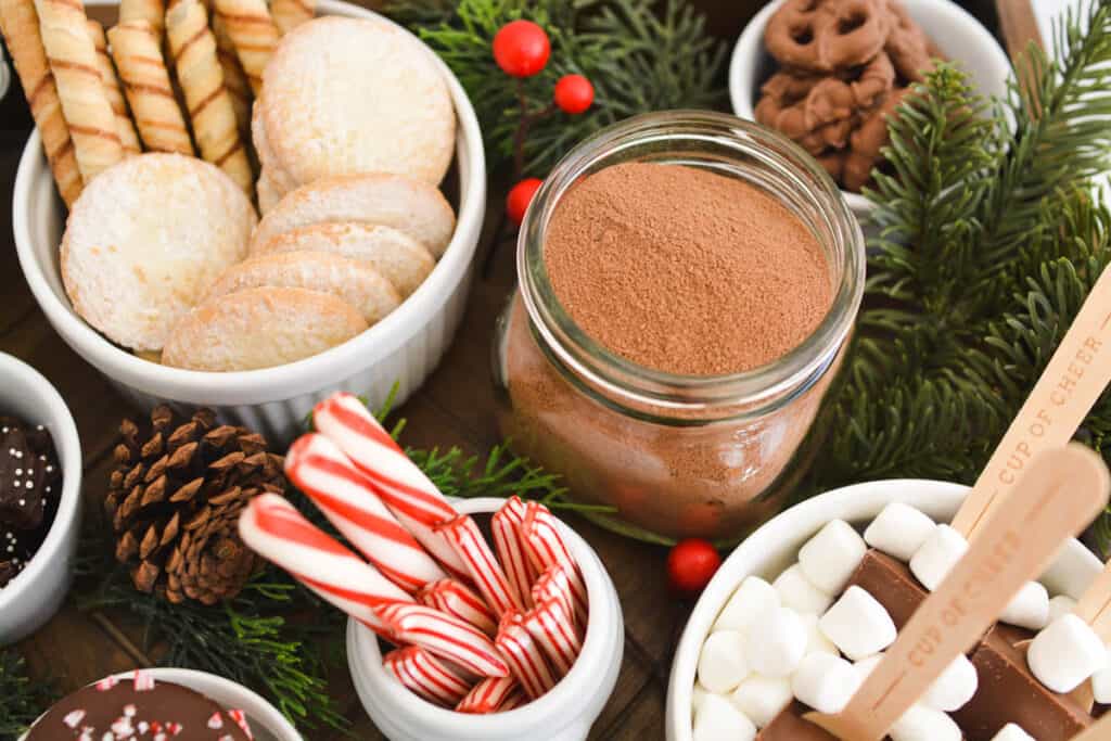 Overhead view of hot cocoa in a jar next to some bowl with toppings.