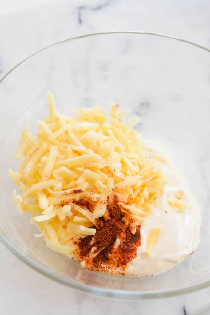 Mixing bowl with cheese, spices, and mayo.