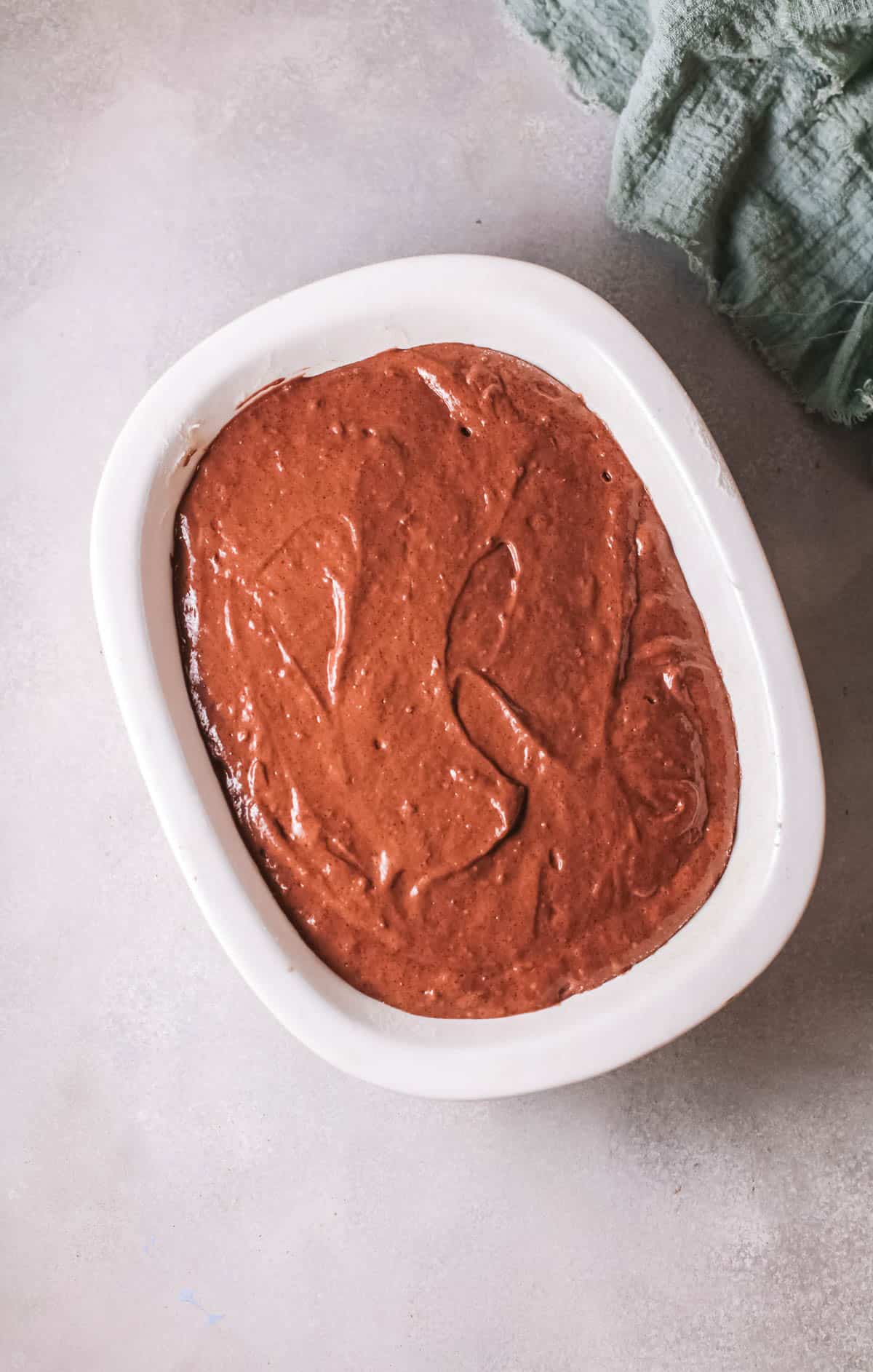 Wet cake batter in a baking dish before cooking.