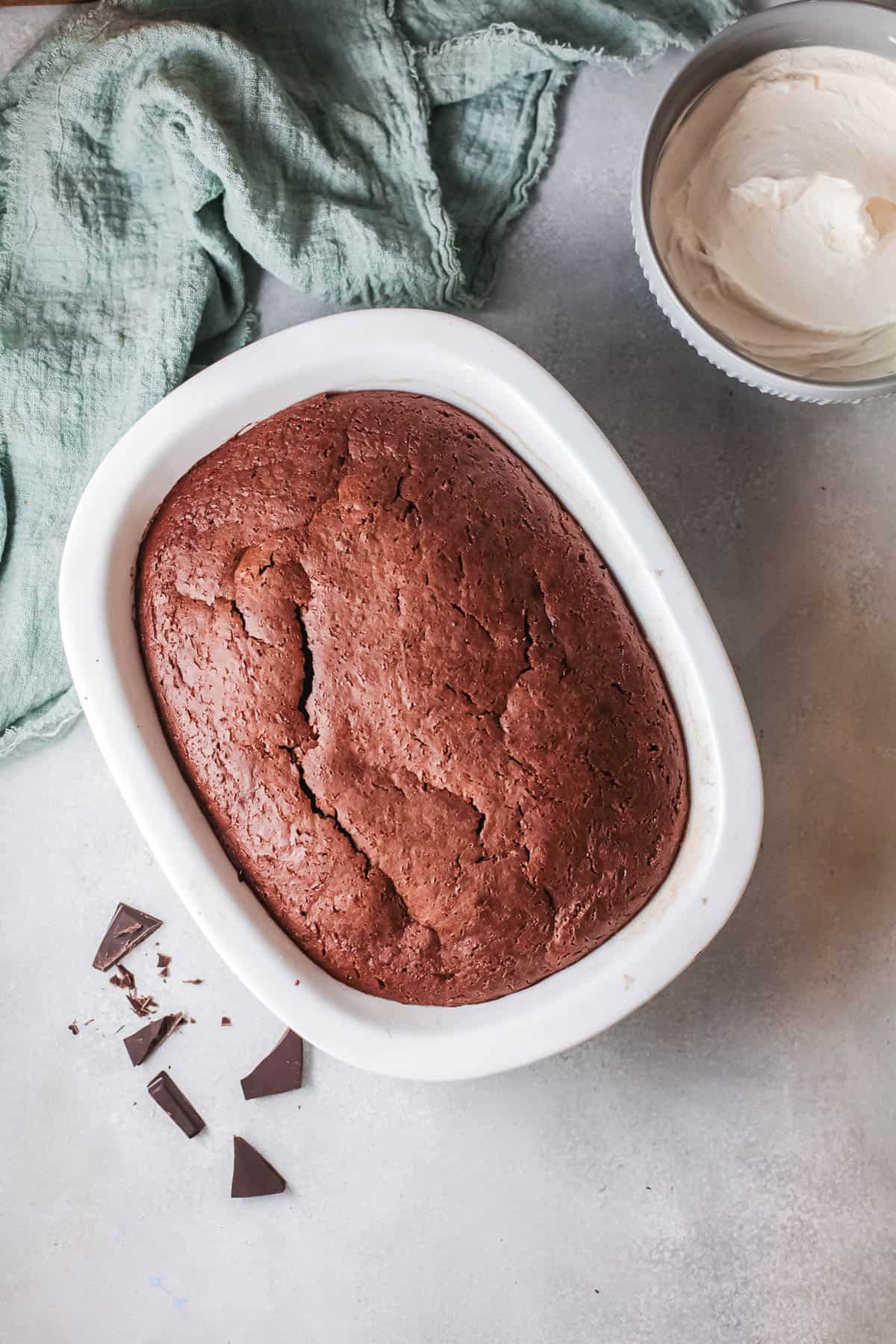 Overhead view of a baked chocolate cake in a dish.