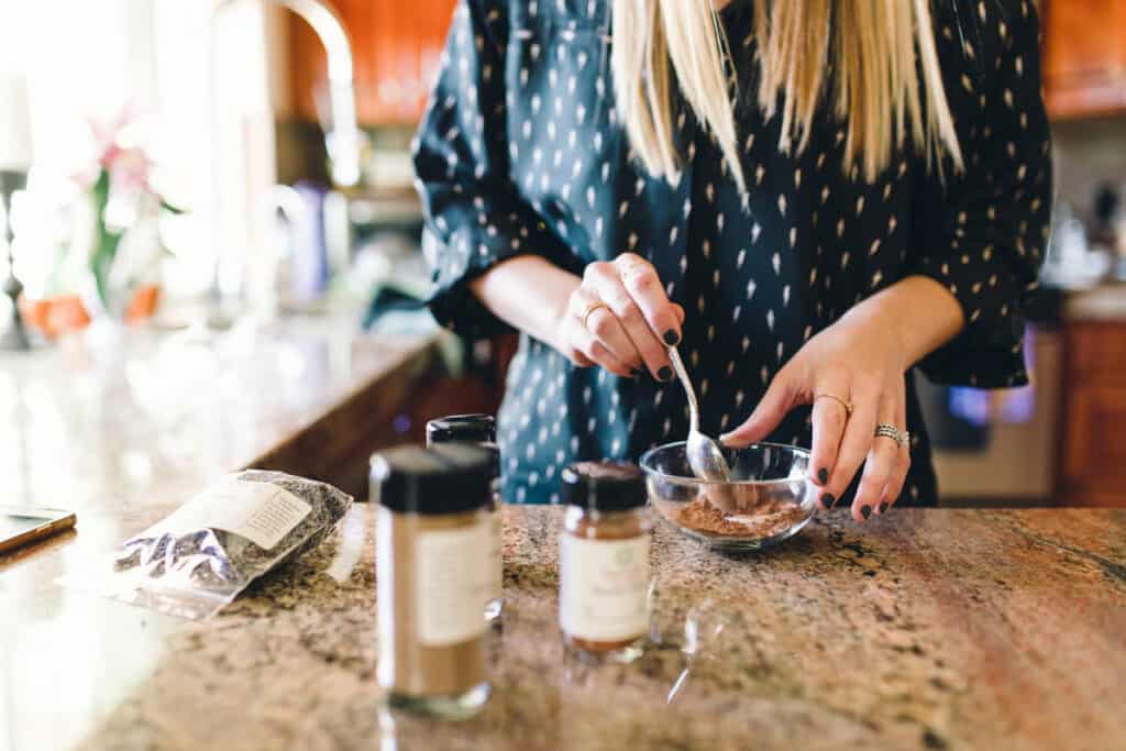 Woman mixing up spices and sugar in a small bowl.