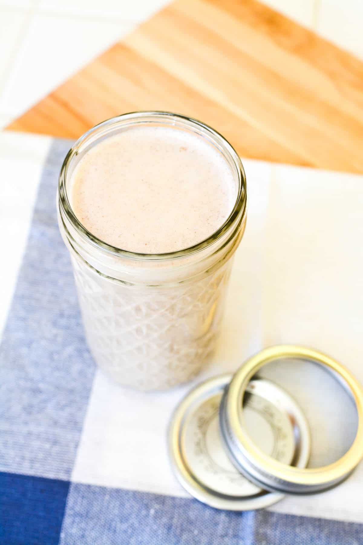 A jar of homemade cinnamon coffee creamer on a counter.