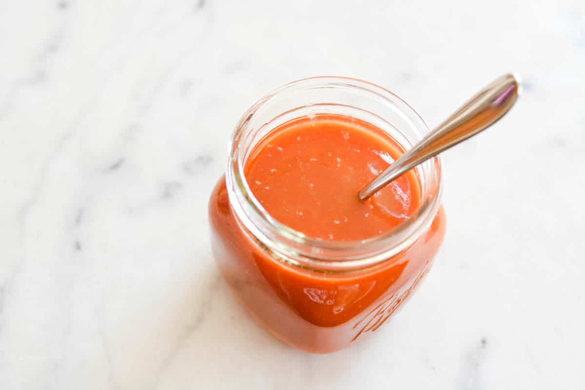 Overhead view of a jar with tomato juice in it.