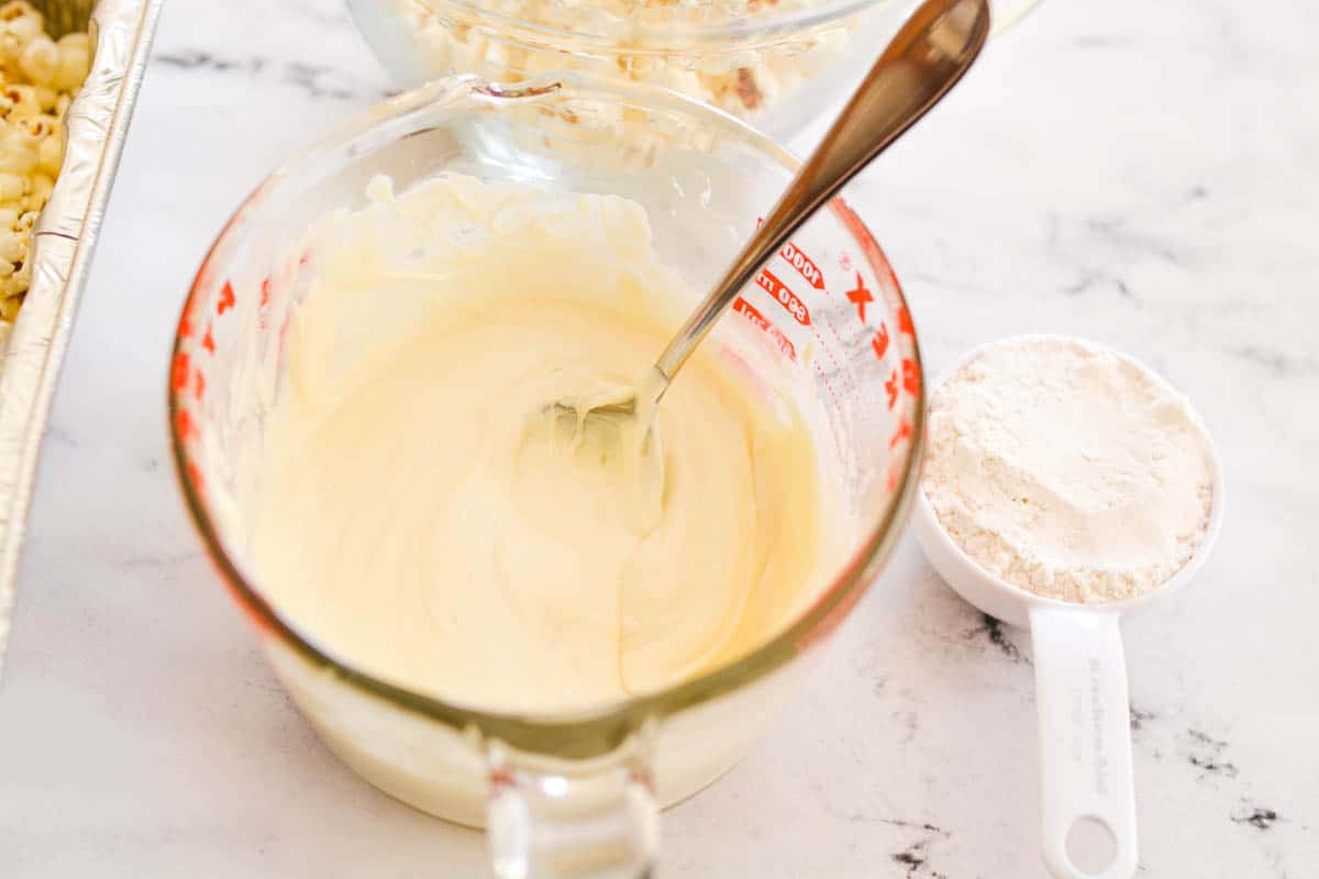 A glass measuring jar with melted white chocolate.