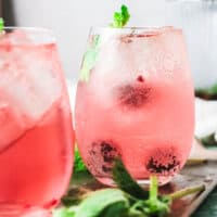 Close up of pink cocktails in stemless wine glasses.