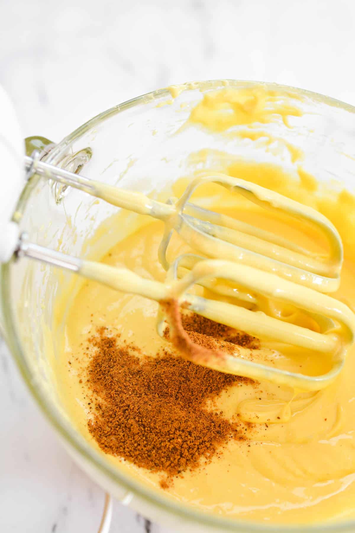 Close up of cake batter in a bowl with nutmeg added.