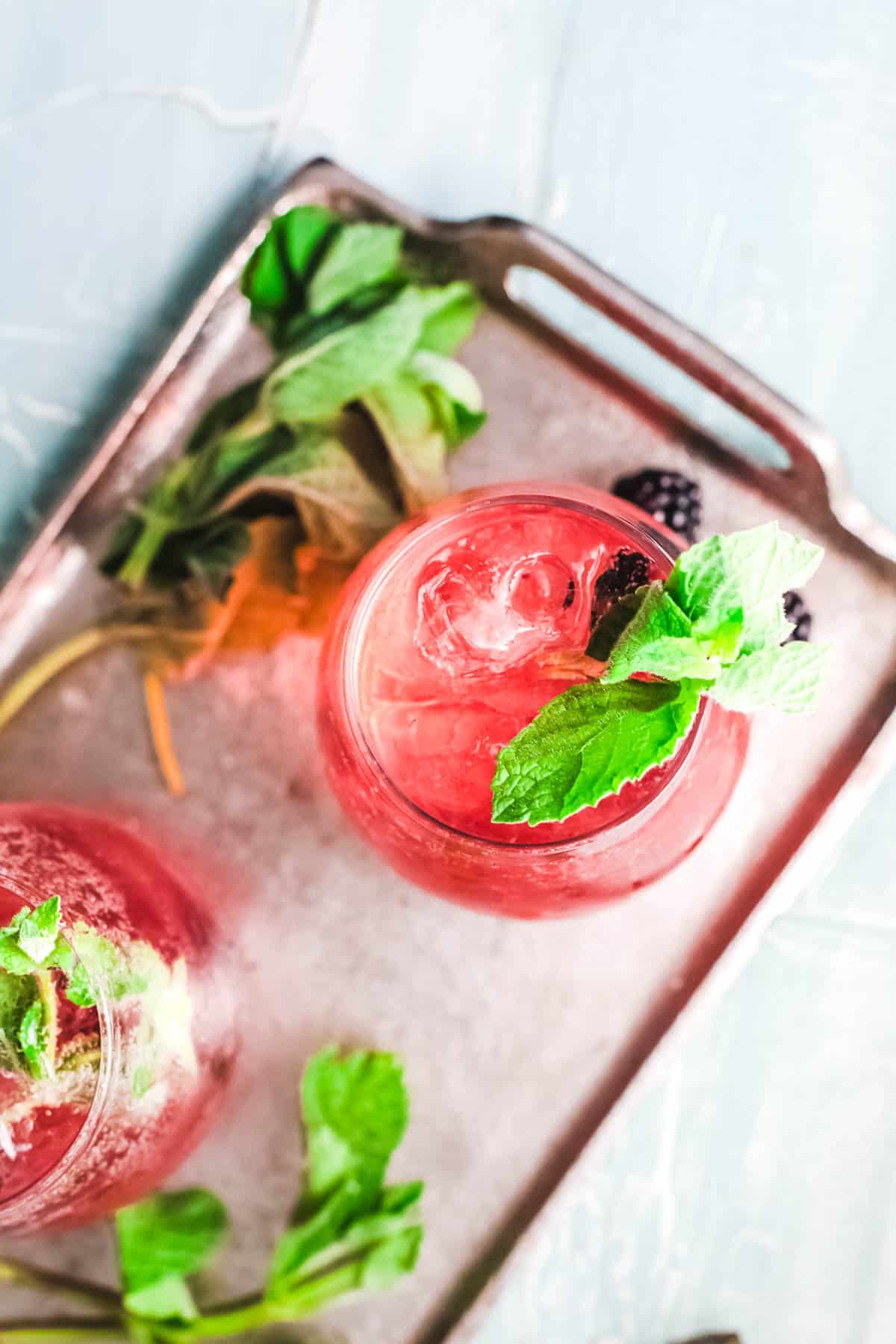 Overhead view of cocktails with a mint garnish.