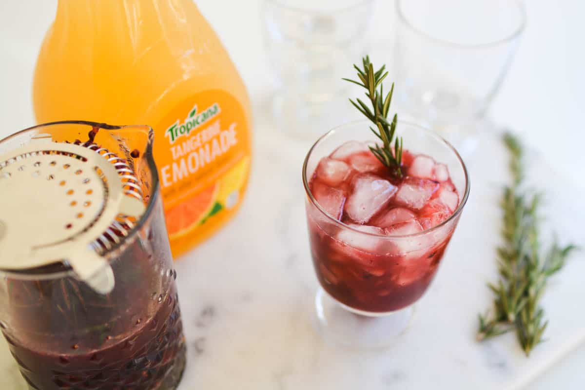 Close up of a blackberry whiskey lemonade cocktail on a table.