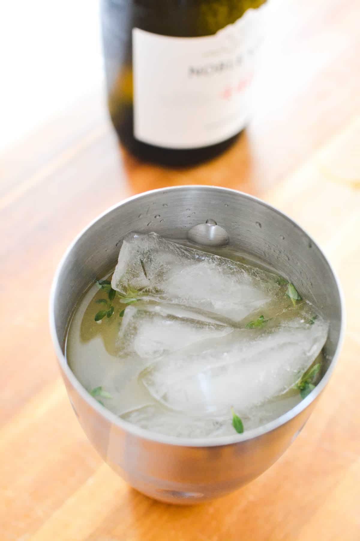 Top down view of a cocktail shaker with liquid and ice.