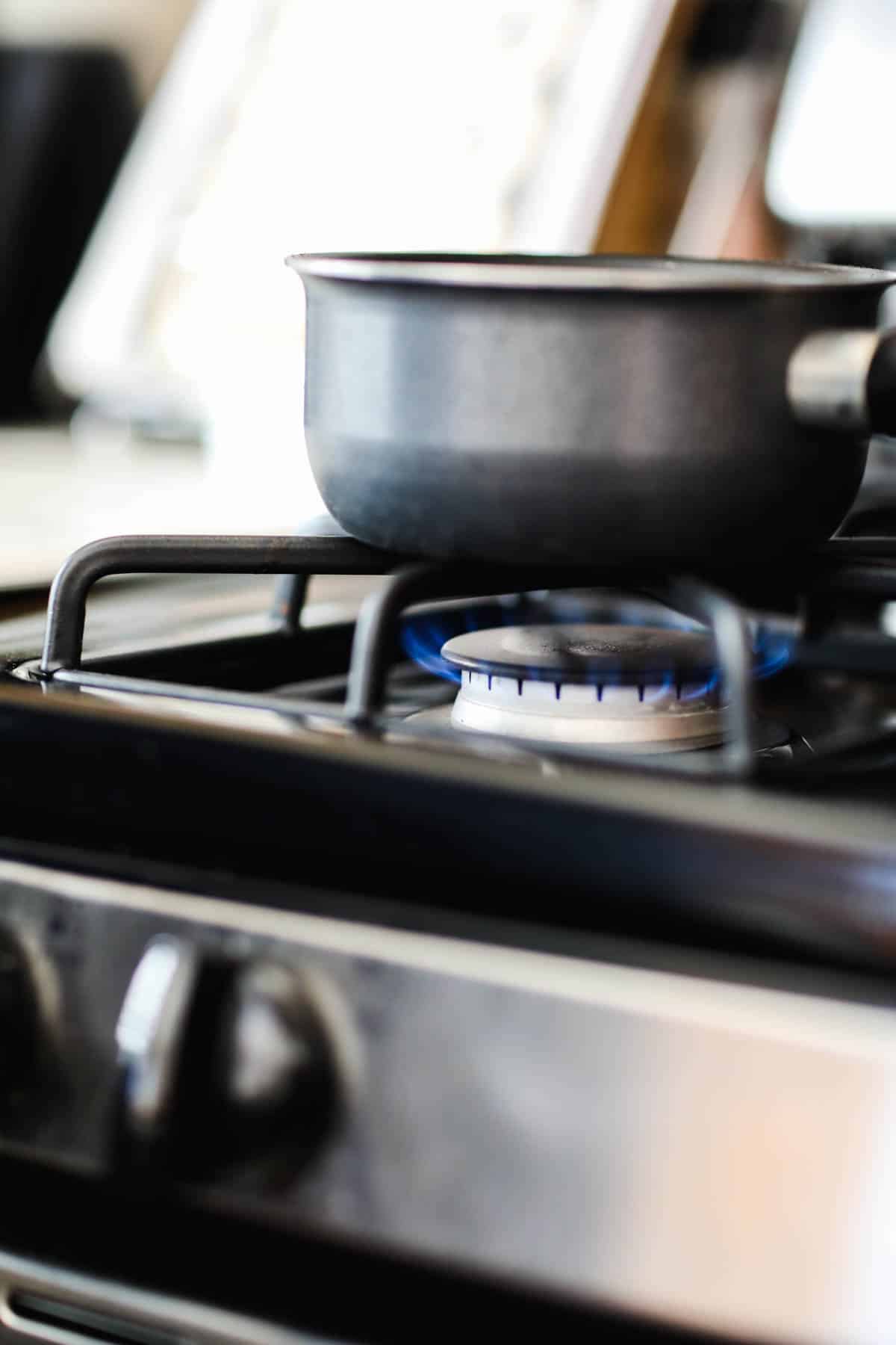 Cooking tea ingredients in a saucepan on the stove.