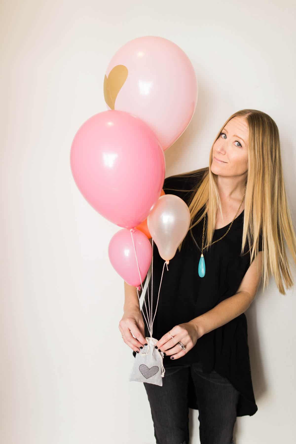 Woman holding a homemade balloon bouquet for valentines day.