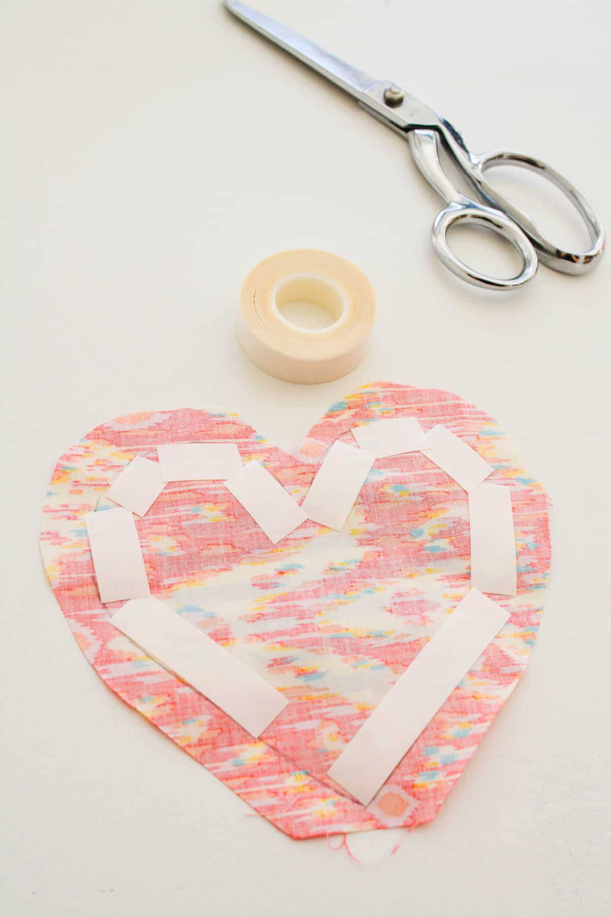 No-Sew tape on the back of a piece of fabric cut in the shape of a heart.