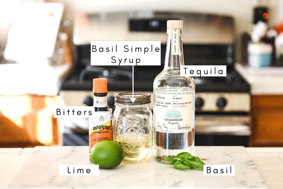 Labeled ingredients for making a basil margarita on a counter. 