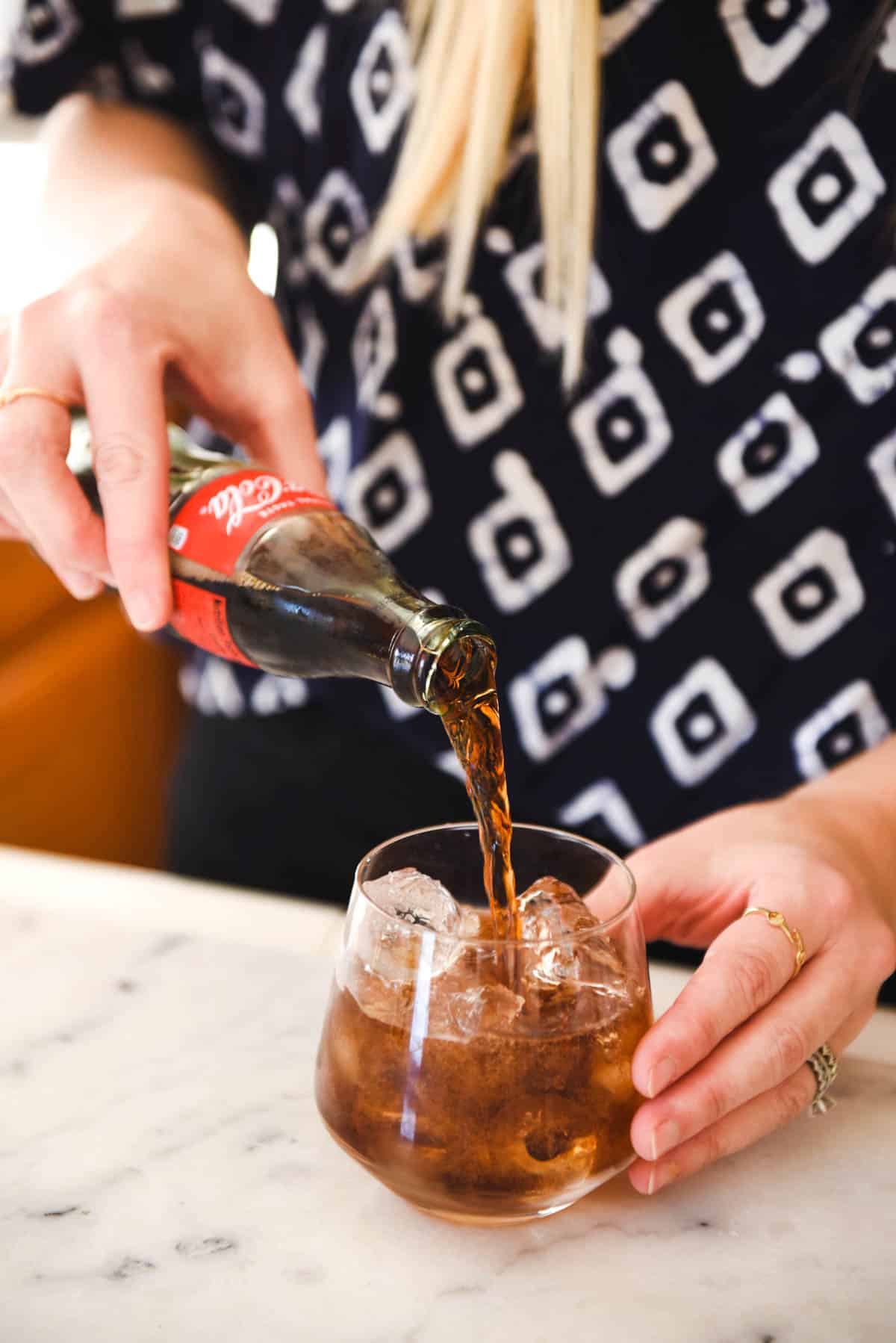 A women pouring in the Coke for this Tequila with Coke recipe.