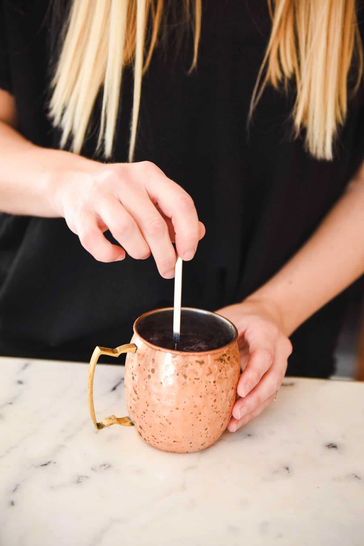 Stirring together the cocktail ingredients to make this Blueberry Mule Cocktail. 