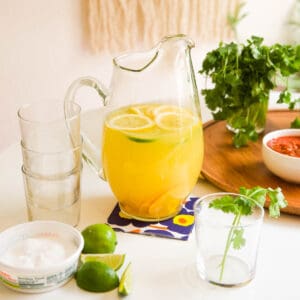 Pitcher of Margarita Sangria recipe with empty glasses, waiting to be poured.