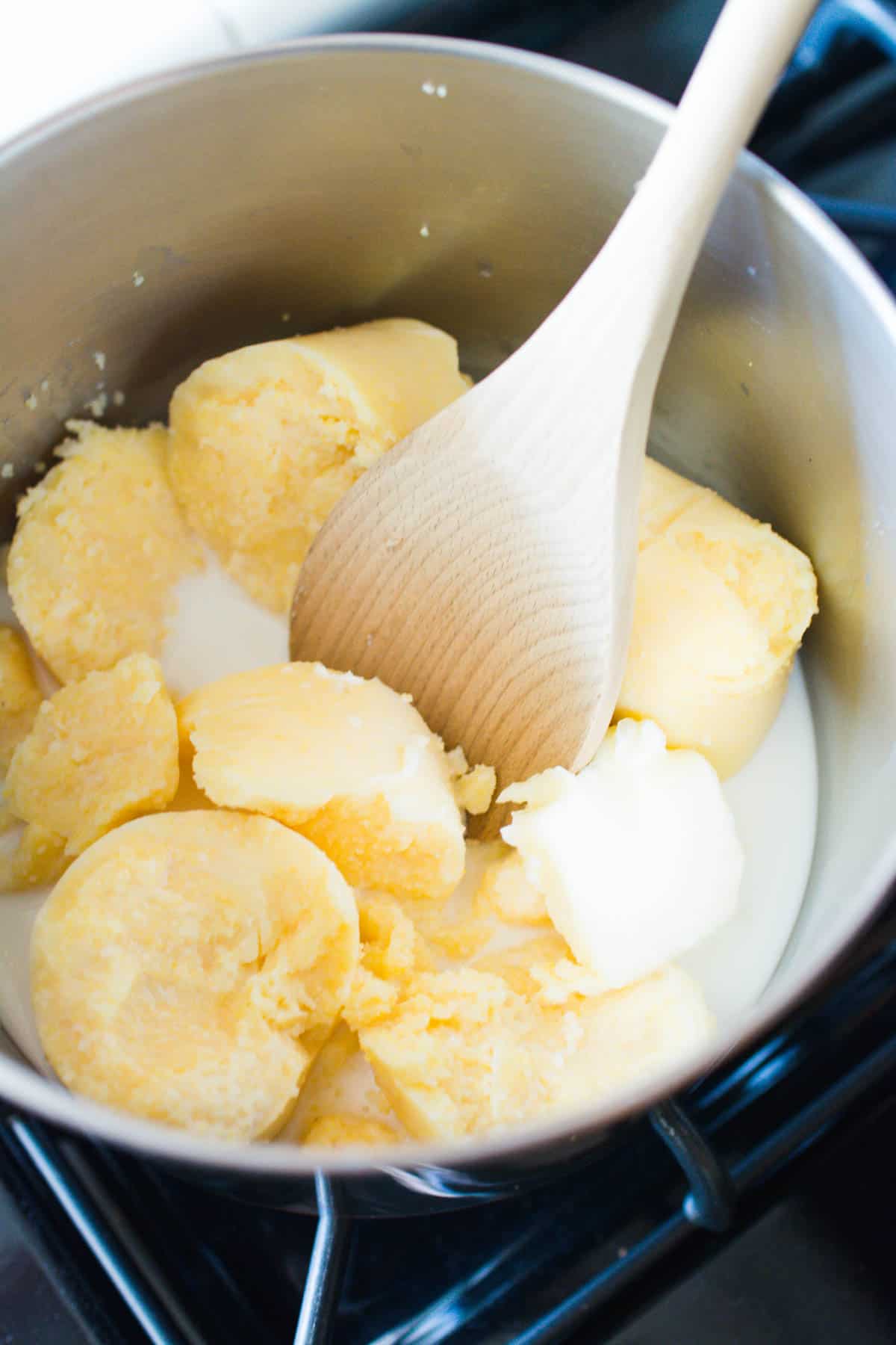 A saucepan with polenta, milk and butter.