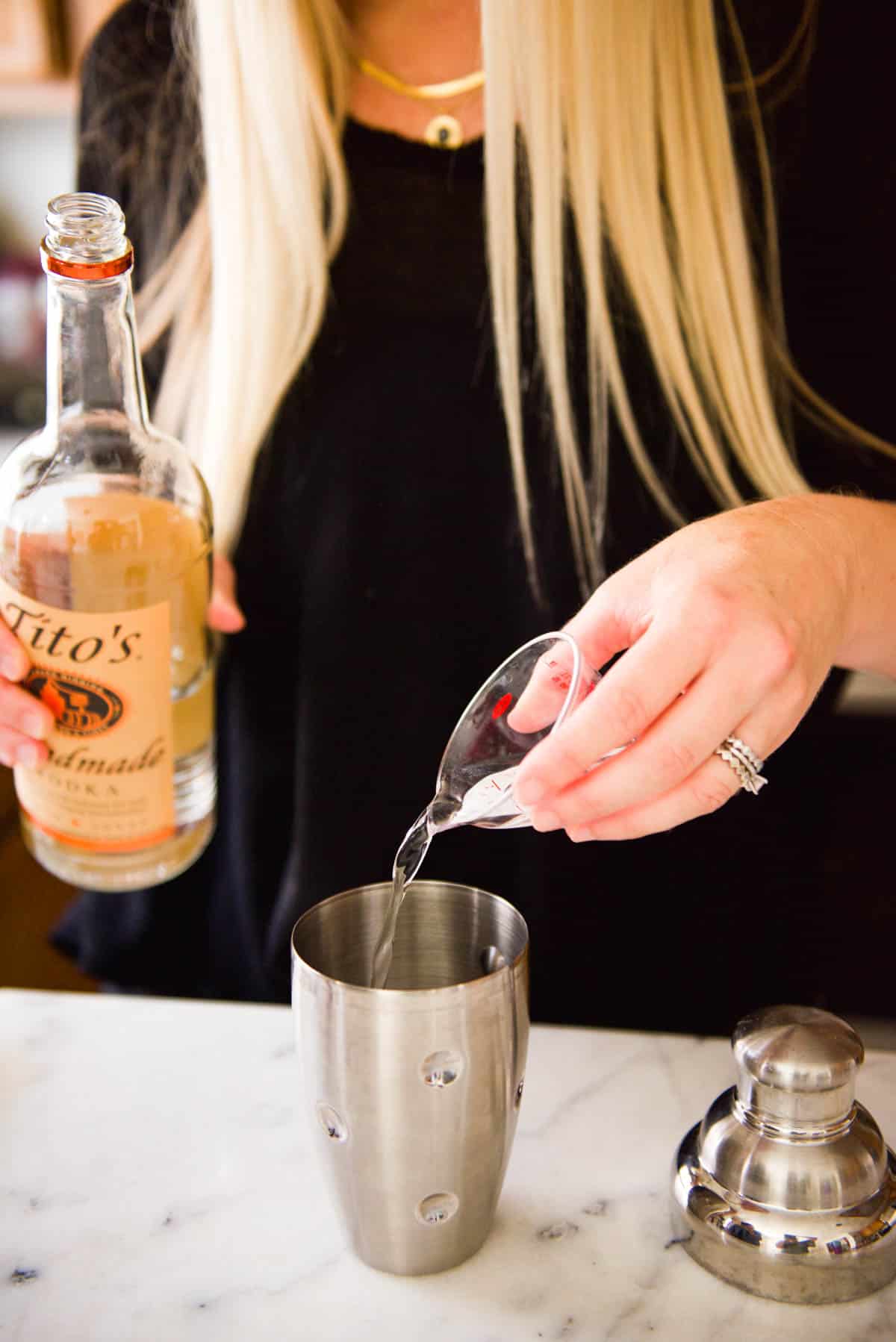 Adding vodka to a cocktail shaker.