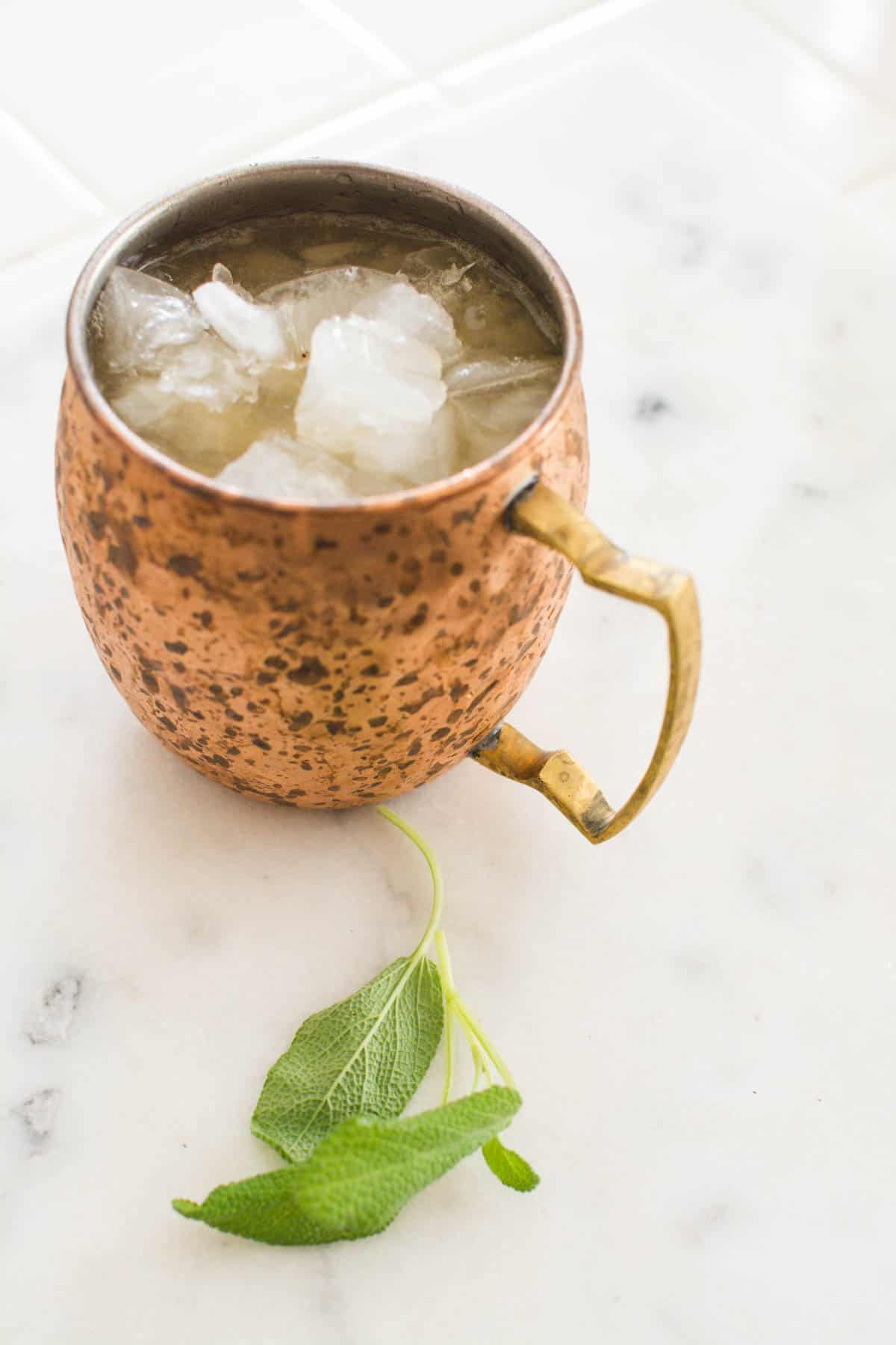 A Moscow Mule with bourbon on a copper mug on a table.
