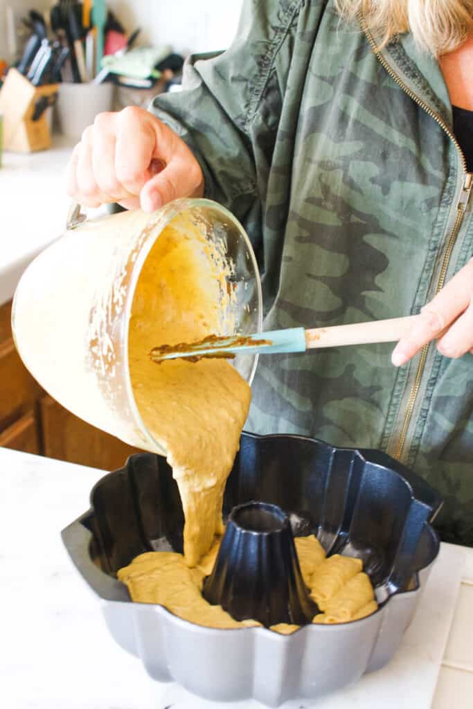 Woman pouring batter into a bundt pan.