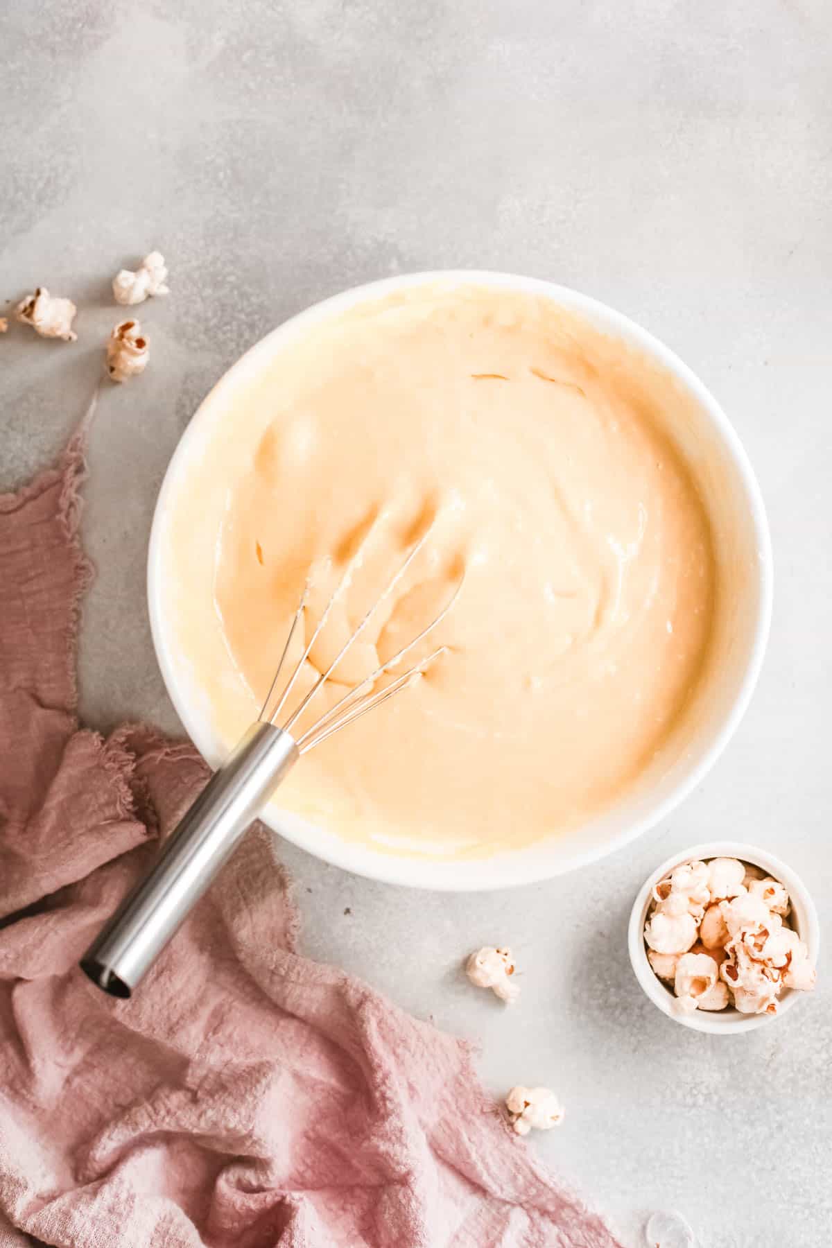 Cupcake batter in a bowl with whisk.