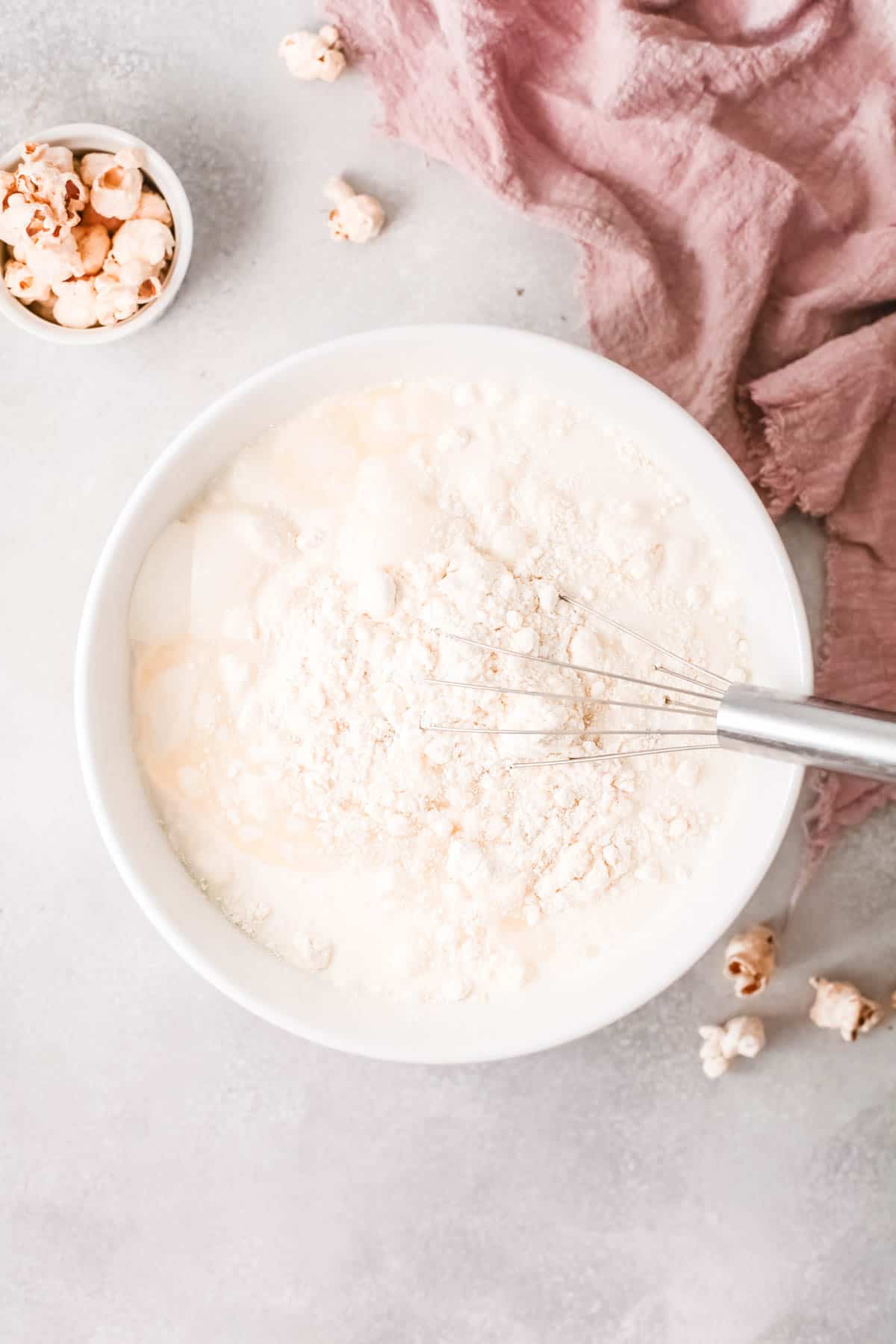 A bowl with cake mix and a whisk in it.