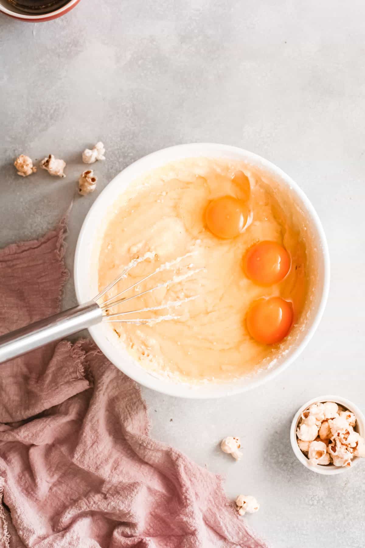 A bowl with eggs and cupcake batter.