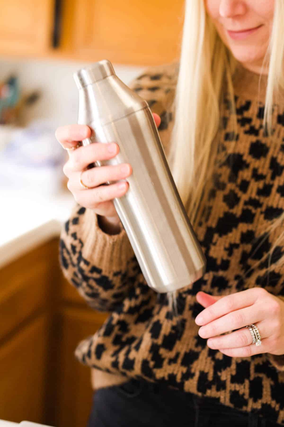 Woman shaking a cocktail shaker.