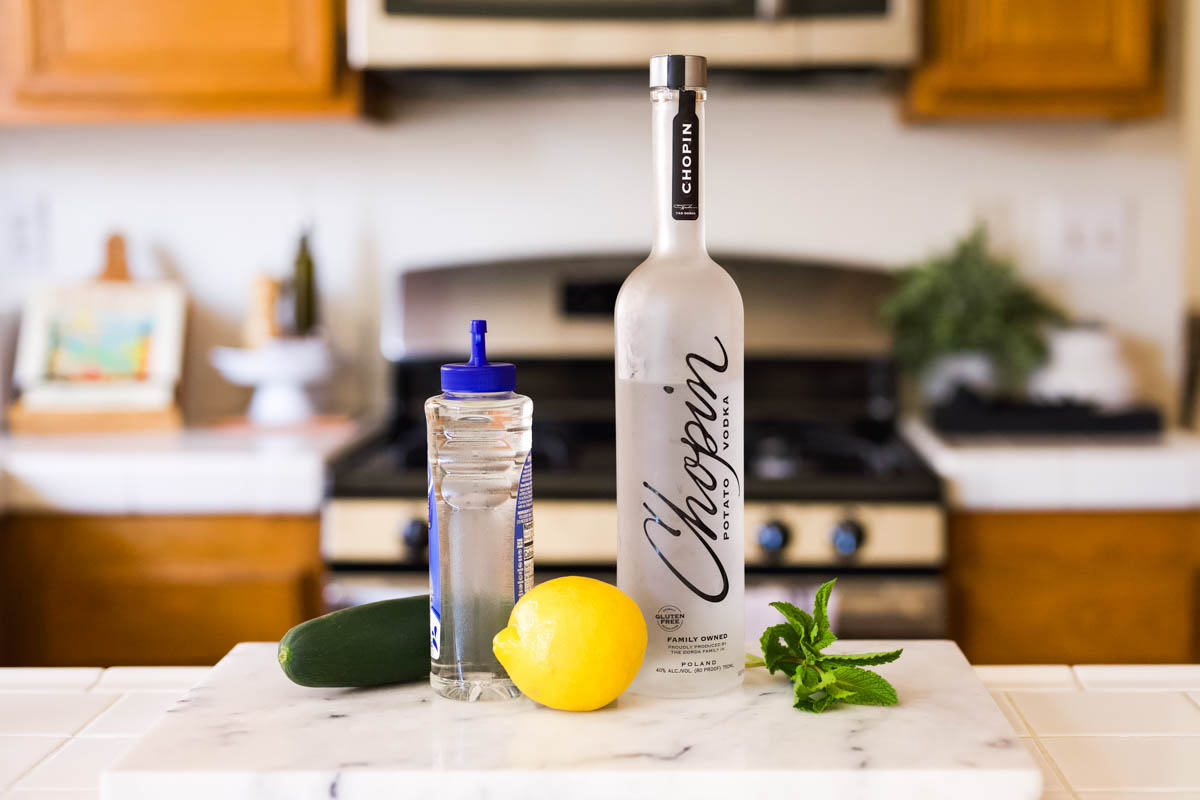 Ingredients on a counter to make a Mint Cucumber Lemonade vodka cocktail.