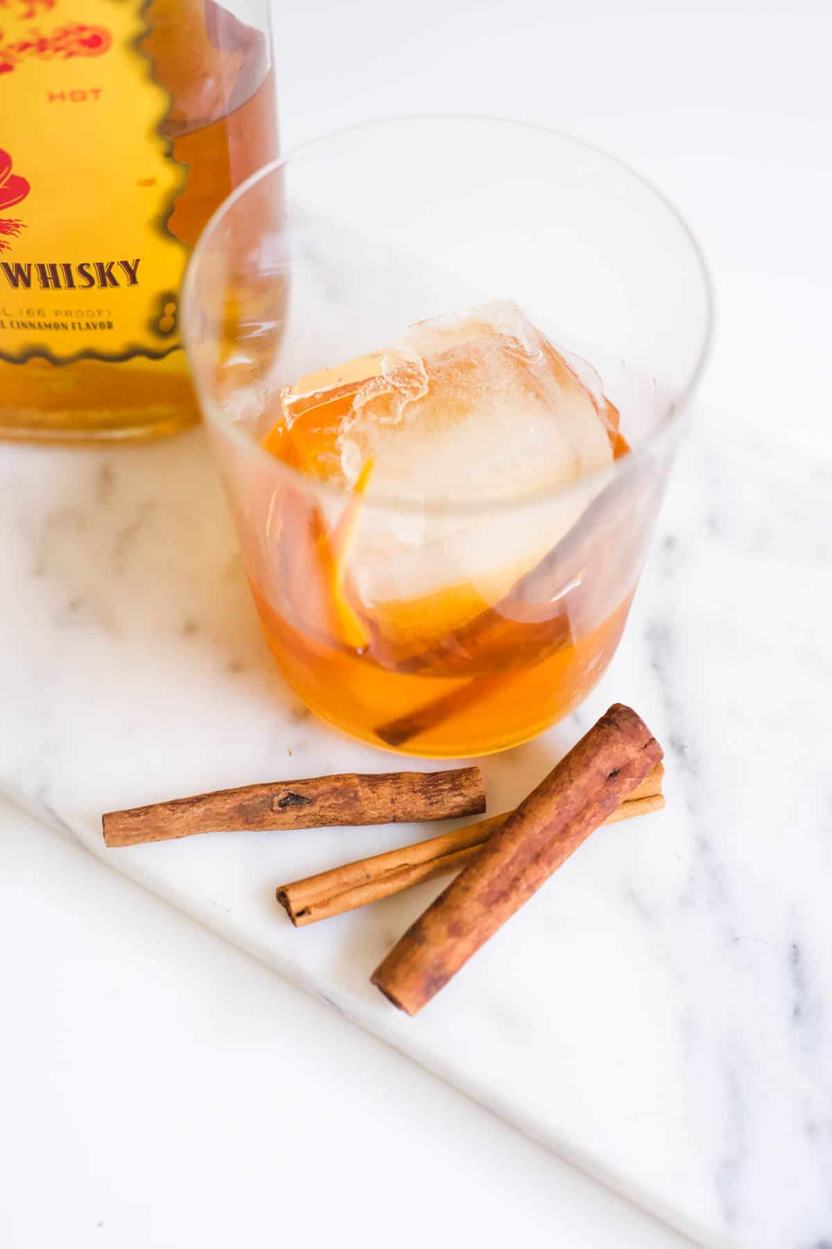 Cinnamon sticks in front of a cocktail glass to be used as a garnish.