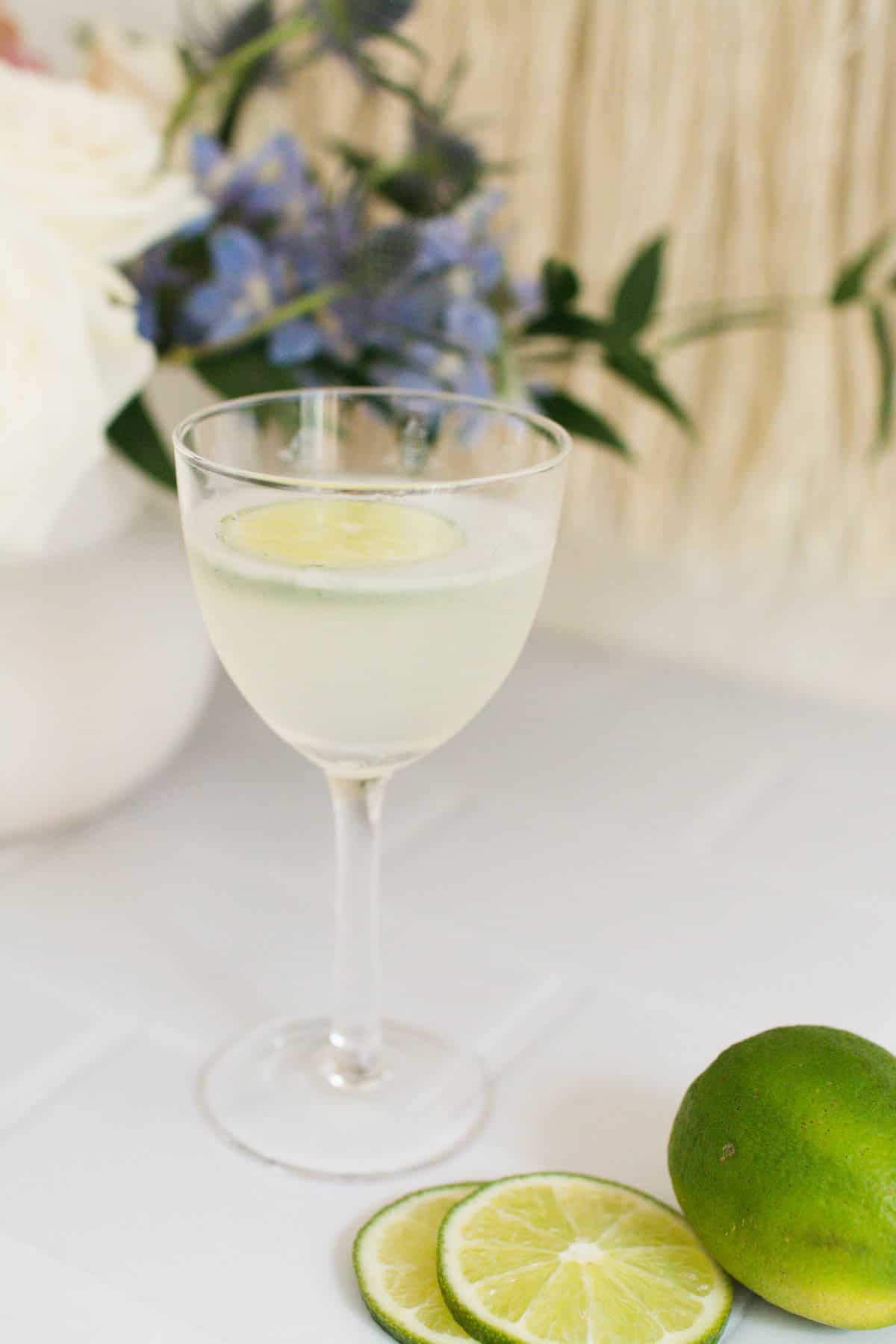 Daiquiri on a table next to a slice lime.