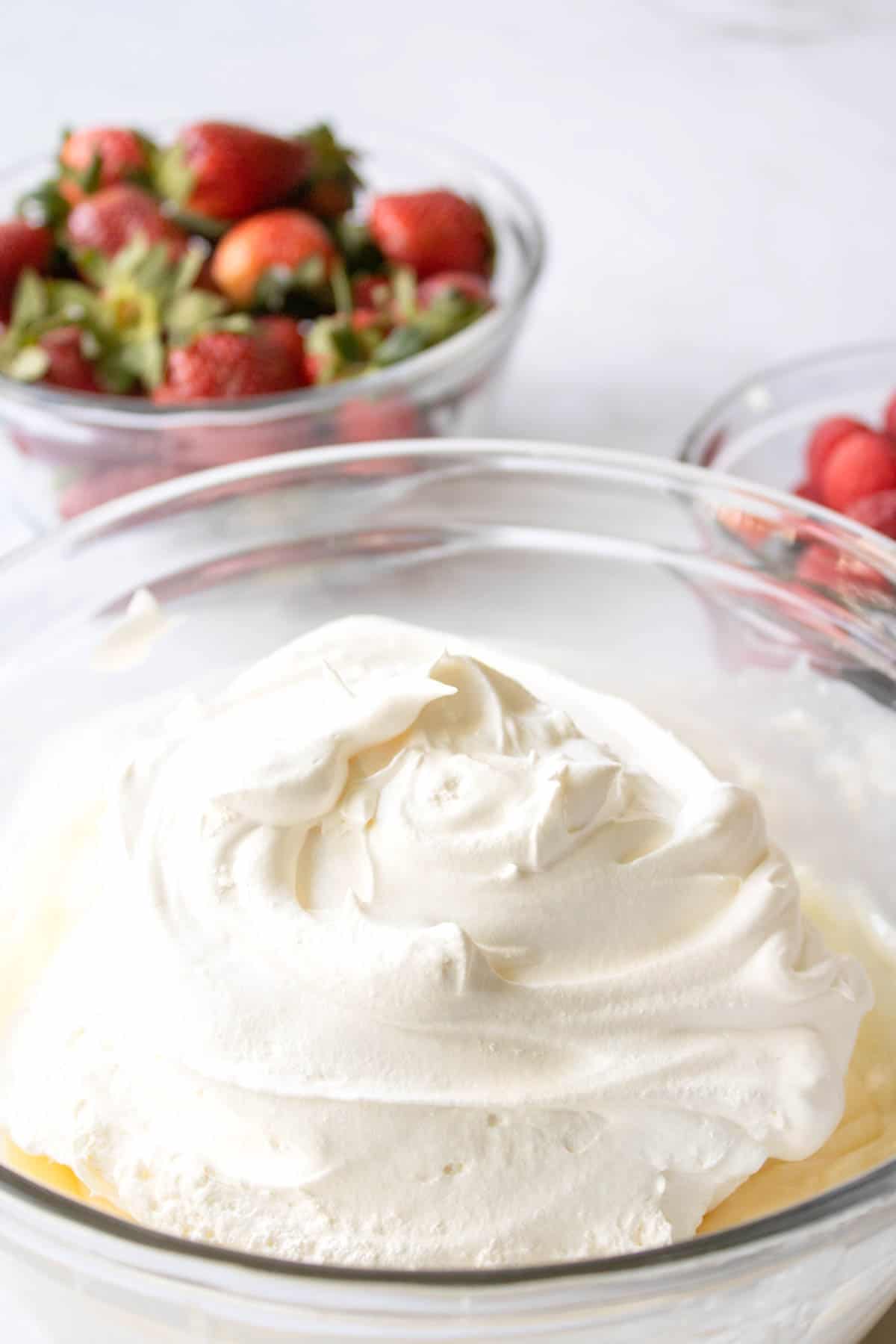 A bowl with vanilla pudding and whipped cream.