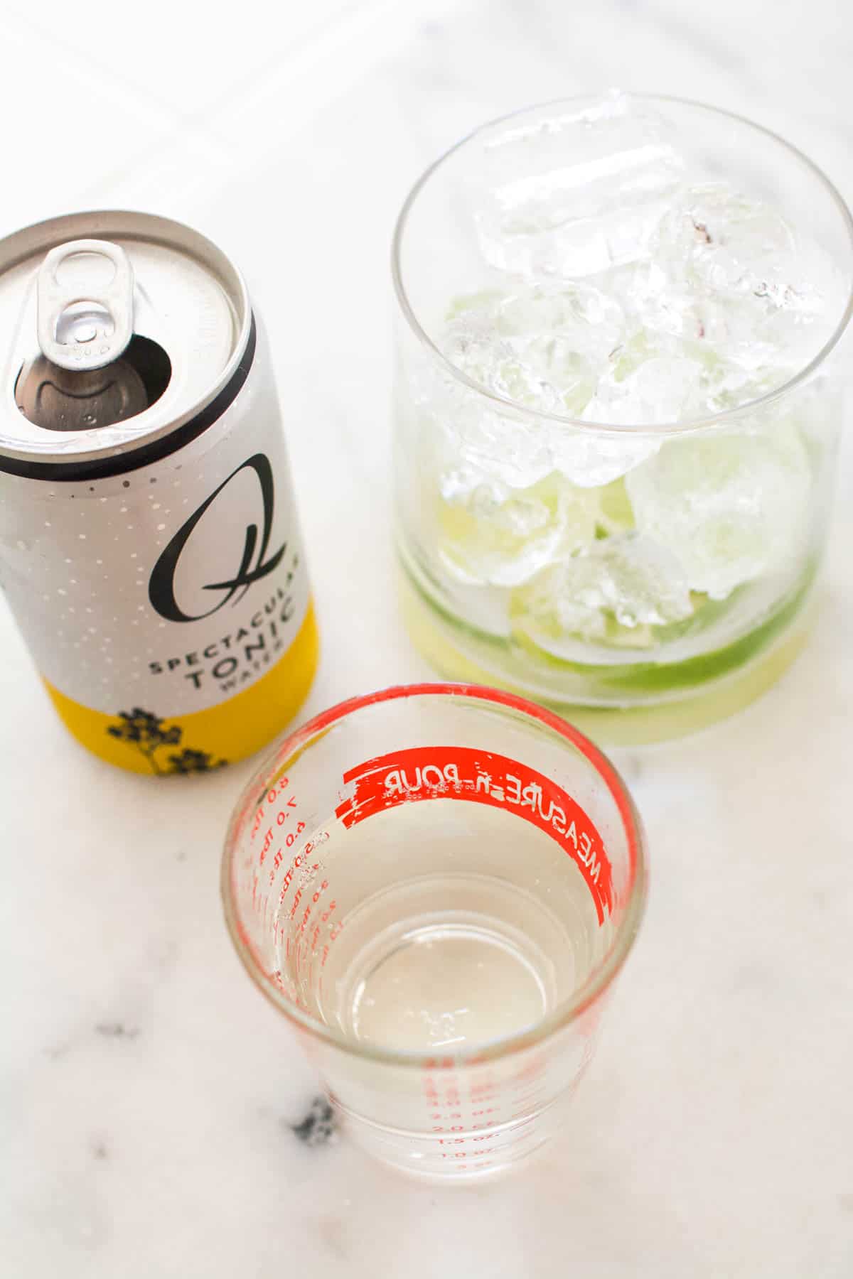 Tonic water being measured for a gin and tonic.