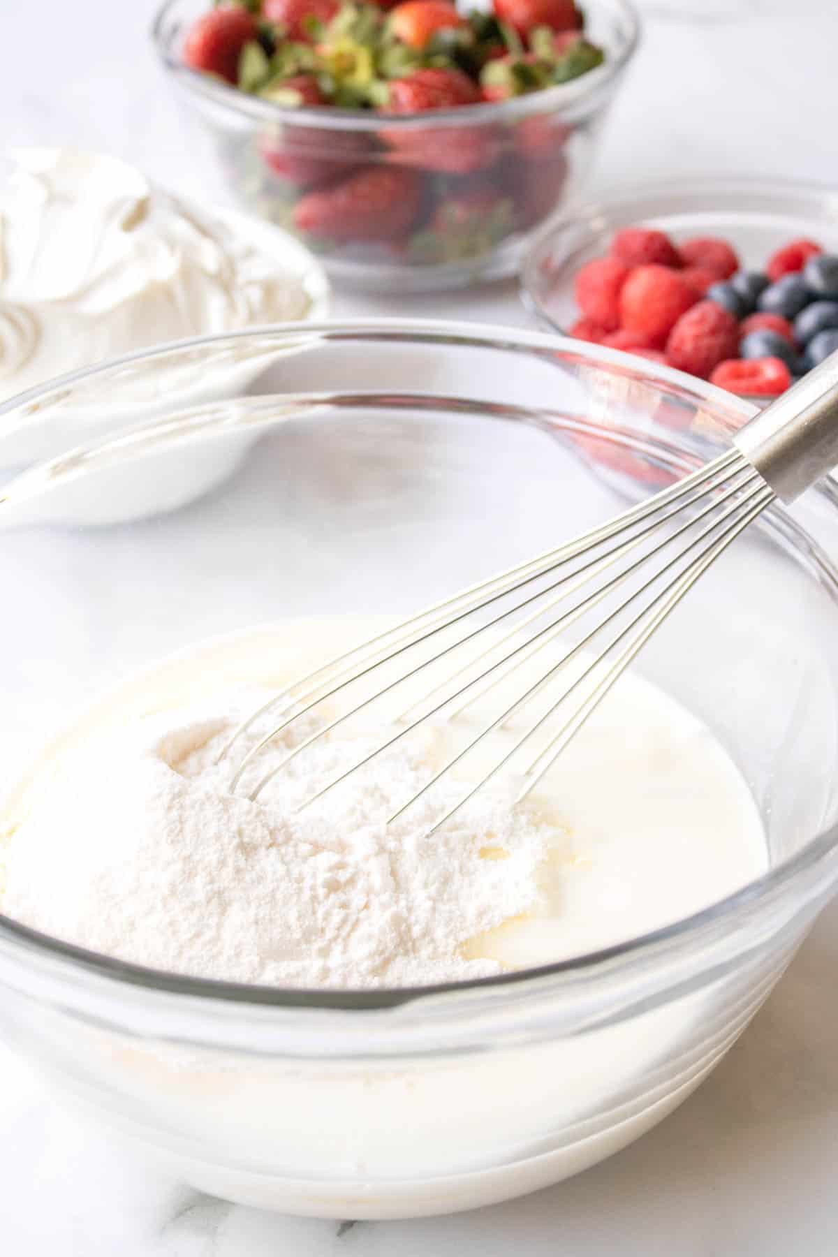 A bowl with cream and pudding in a mixing bowl.