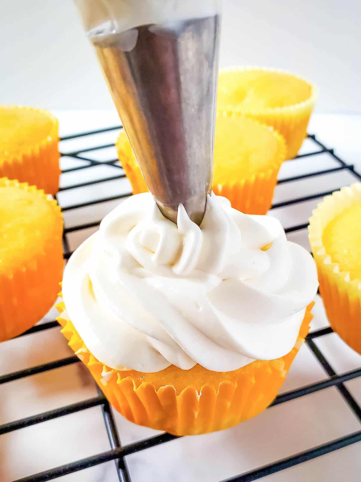 Frosting pineapple cupcakes.