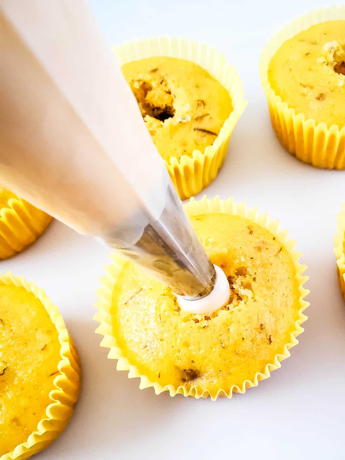 Filling a cupcake with banana pudding.