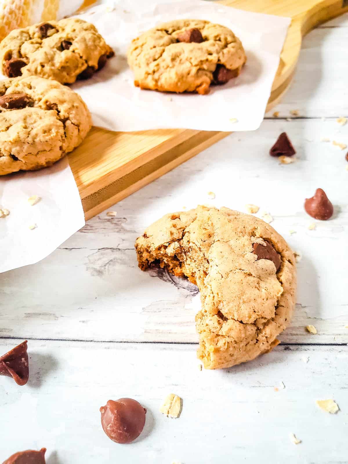 Close up of a spice cake mix oatmeal chocolate chip cookie with a piece out of it.