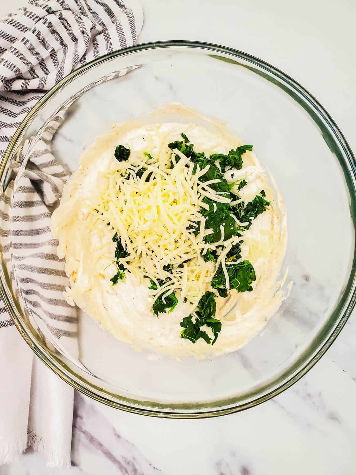 Dip mix, cheese and spinach in a glass bowl.