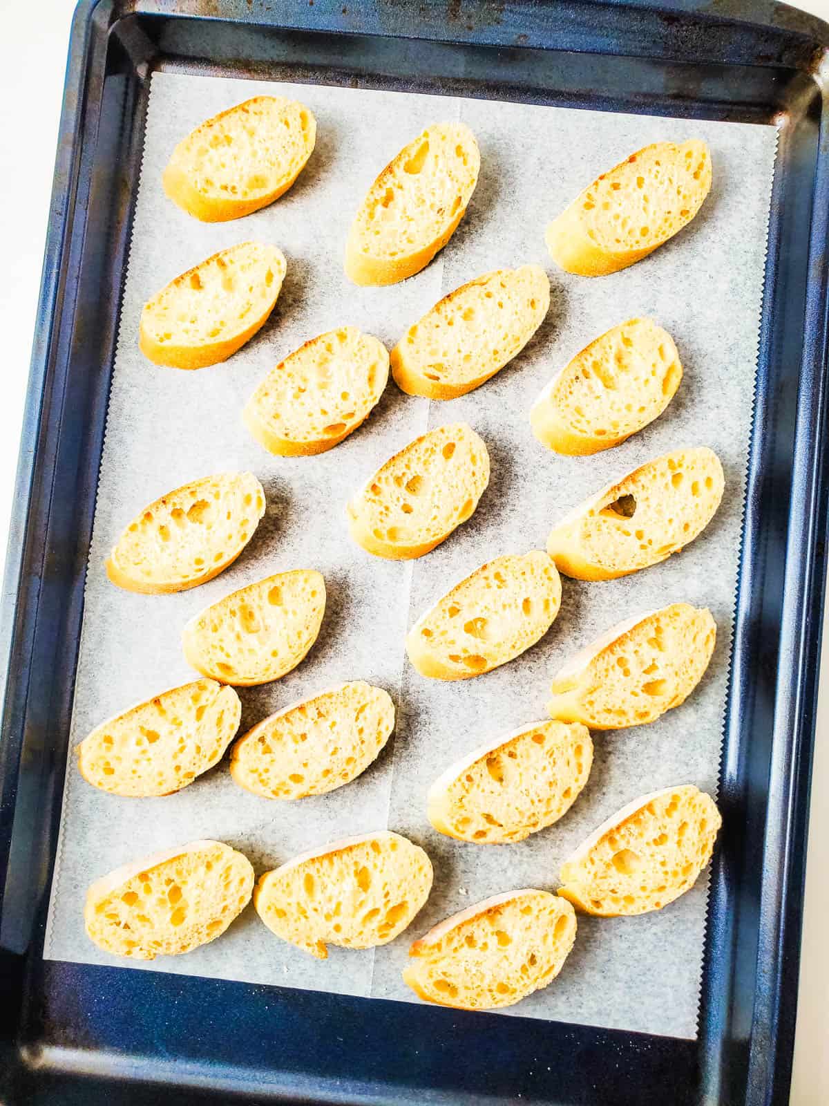 Sliced baguette on a cookie sheet.