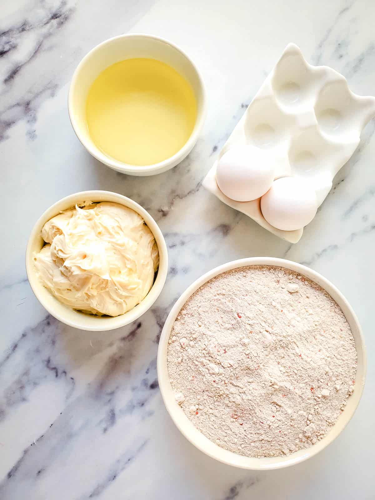 Ingredients in bowls on a counter to make cake mix cookies with carrot cake mix.