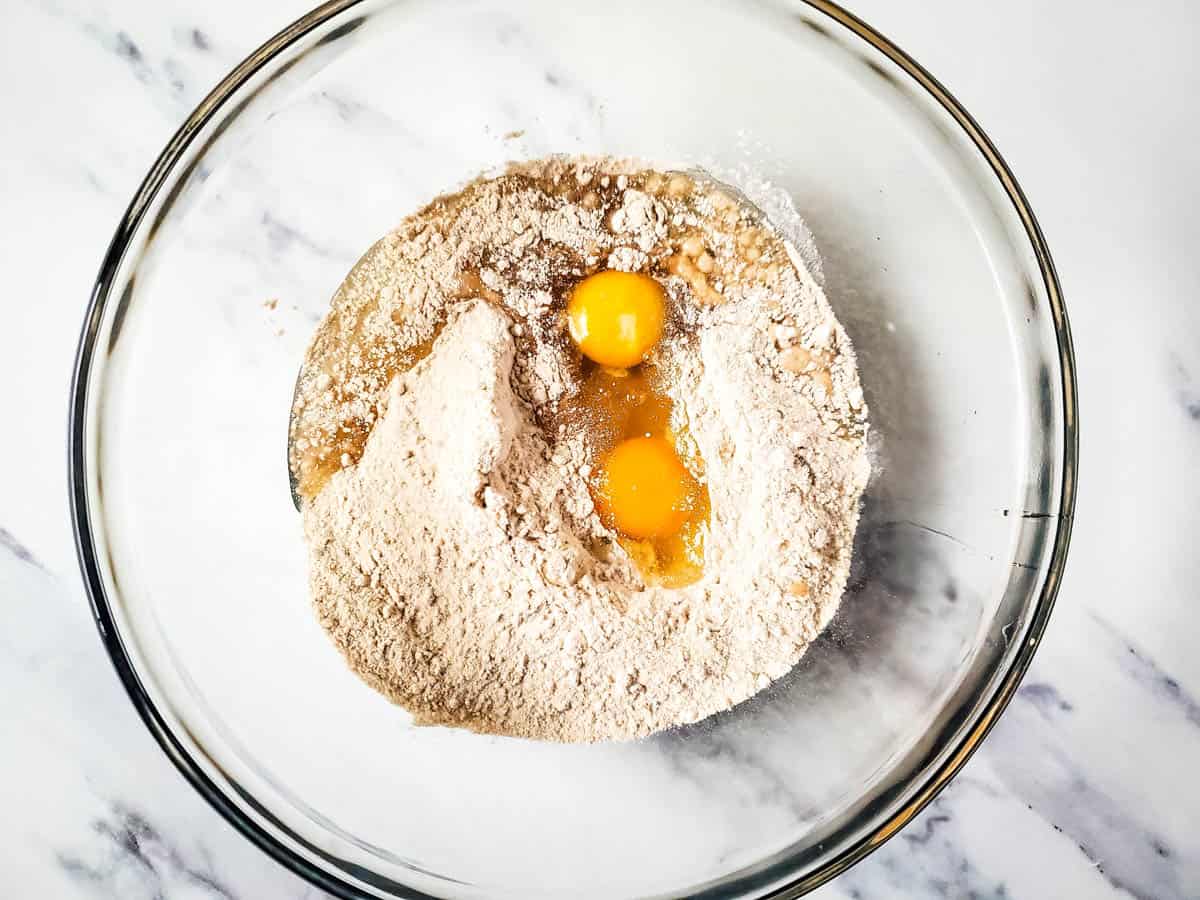 A mixing bowl with dry spice cake mix and eggs to make cookies with.