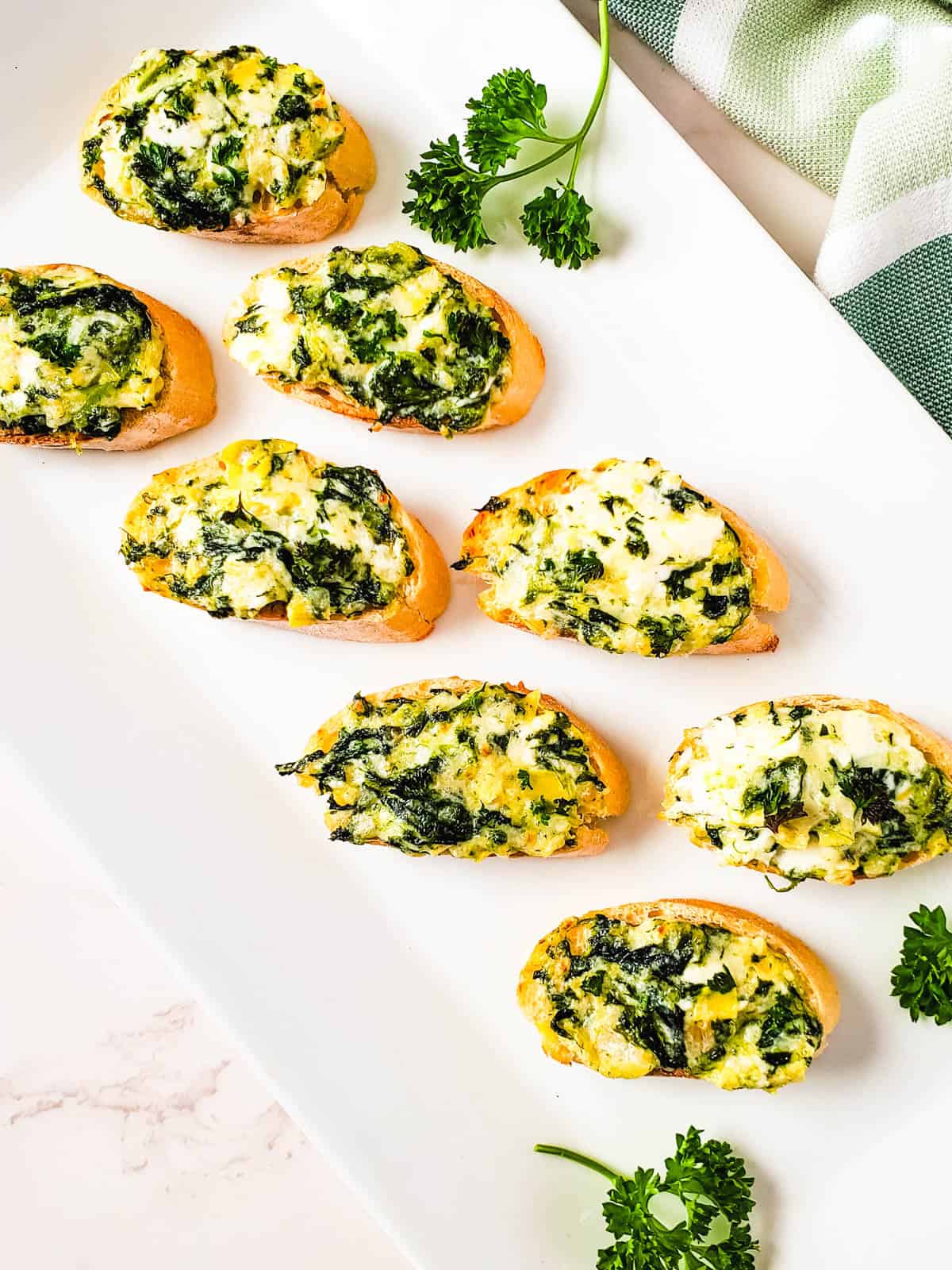 A spinach and artichoke appetizer on a white platter.