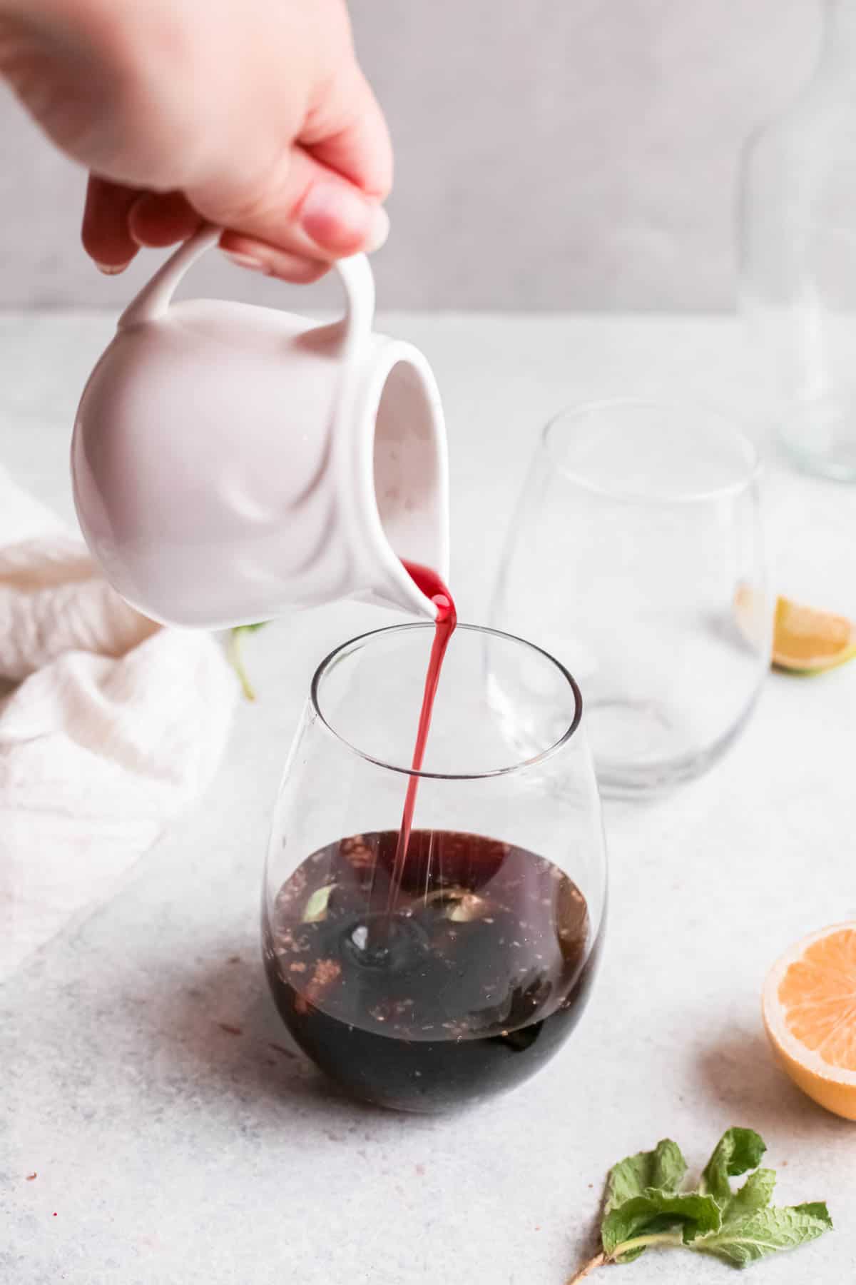 Cherry juice being poured into a cocktail glass.