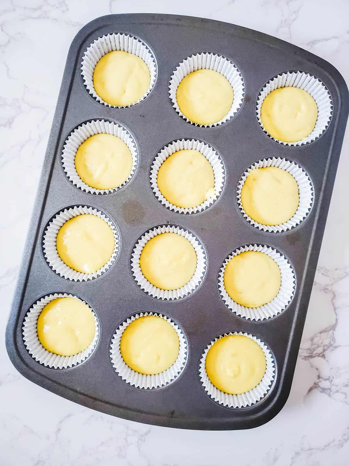 Coconut cupcake batter on a cupcake pan.