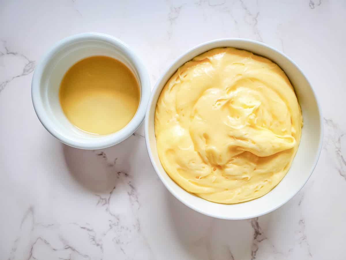 Rum and buttercream frosting for spiced rum cupcakes in bowls on a counter.