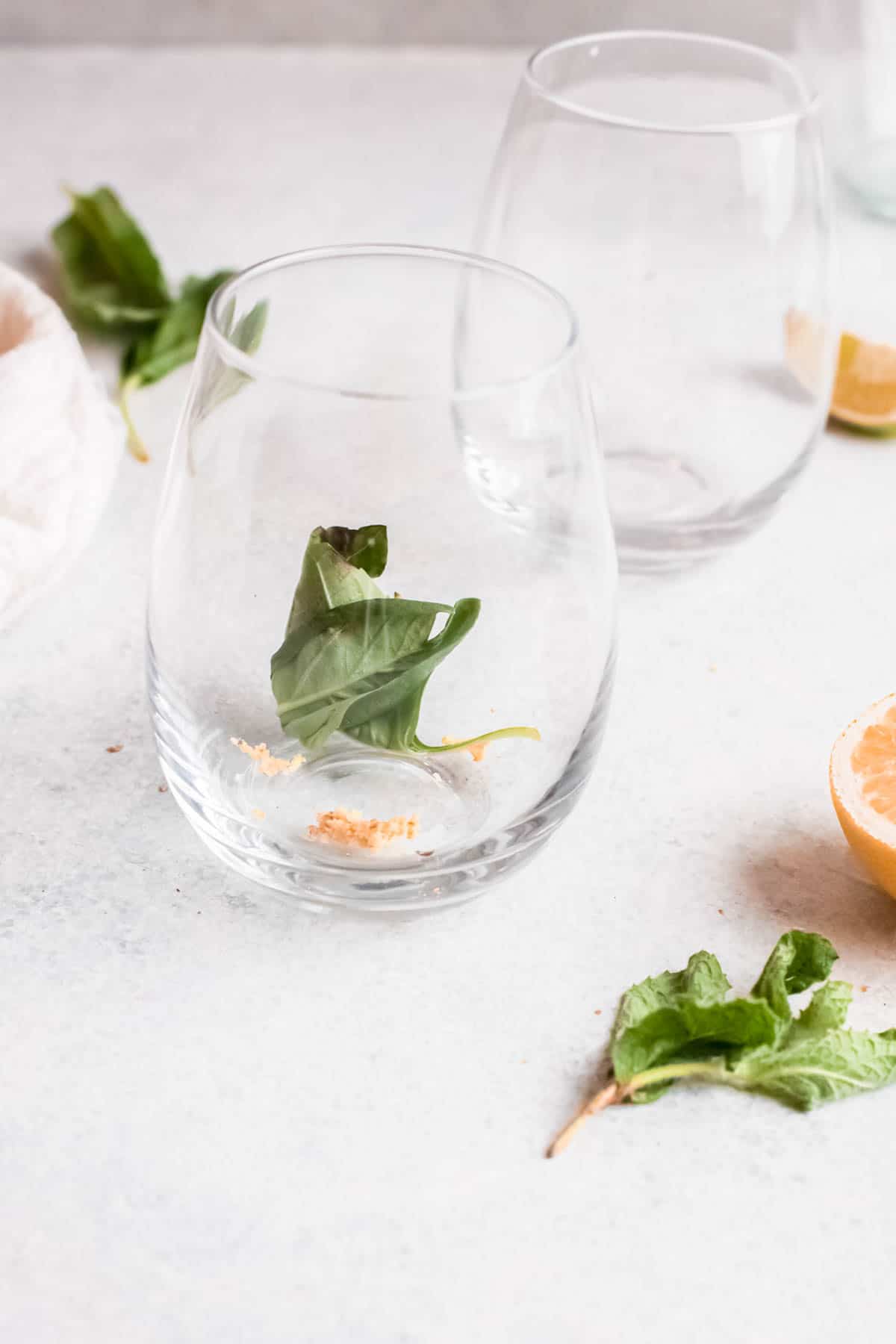 Cocktail glass with grated ginger and mint leaves in the bottom. 