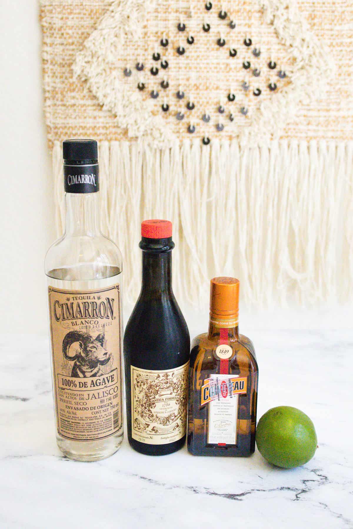 Ingredients for a tequila martini lined up on a countertop.