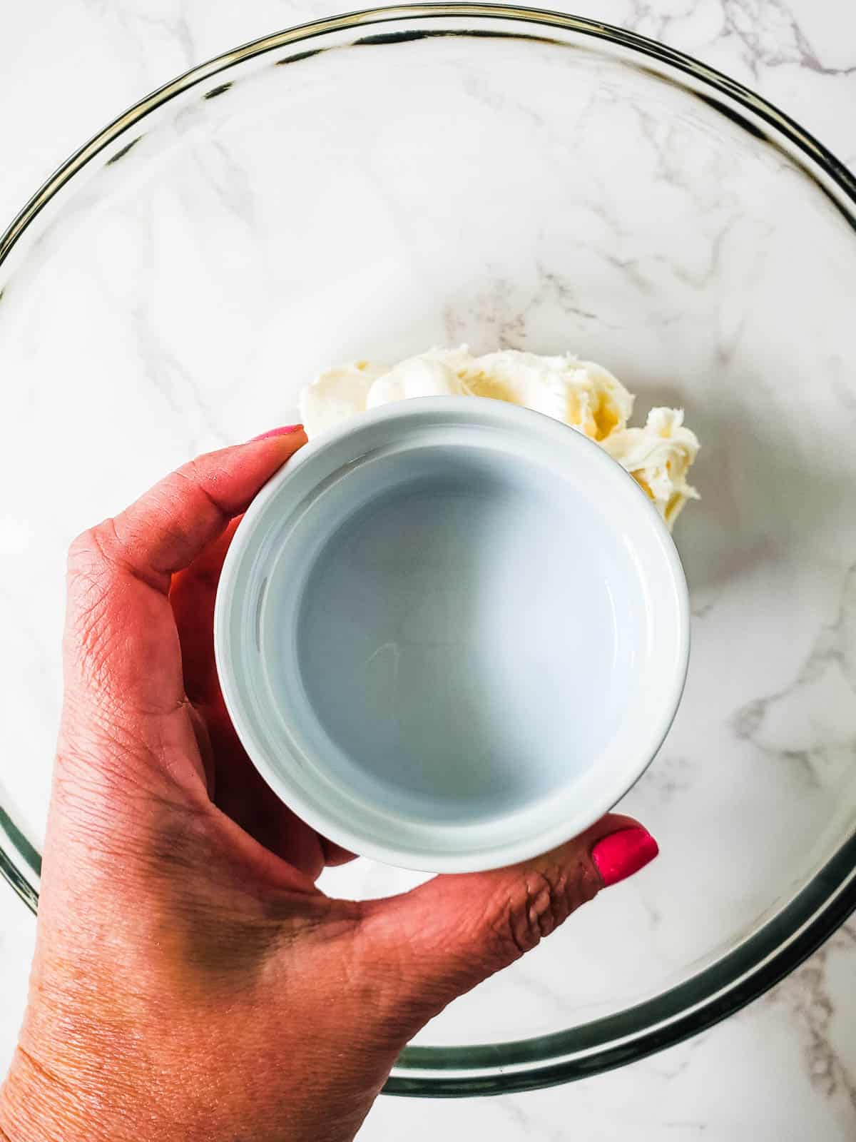 Rum in a ramekin for boozy pina colada cupcakes.