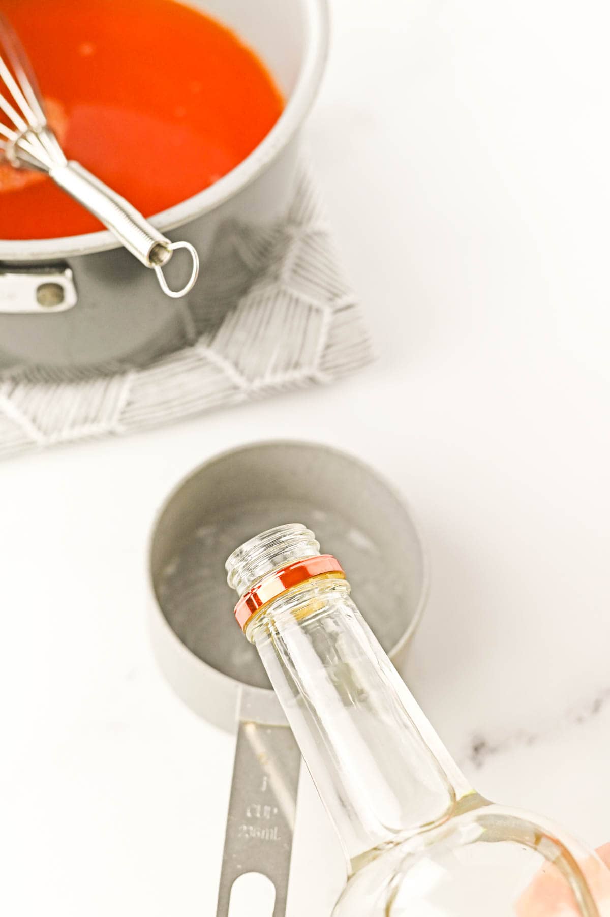 Vodka being poured into a measuring cup.